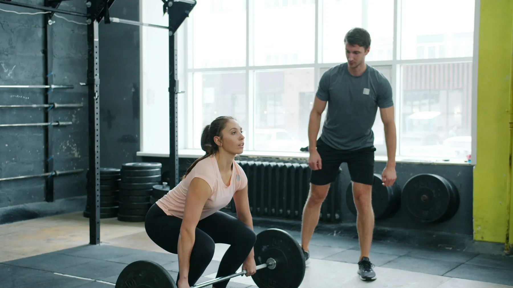 A trainer coaching a deadlift